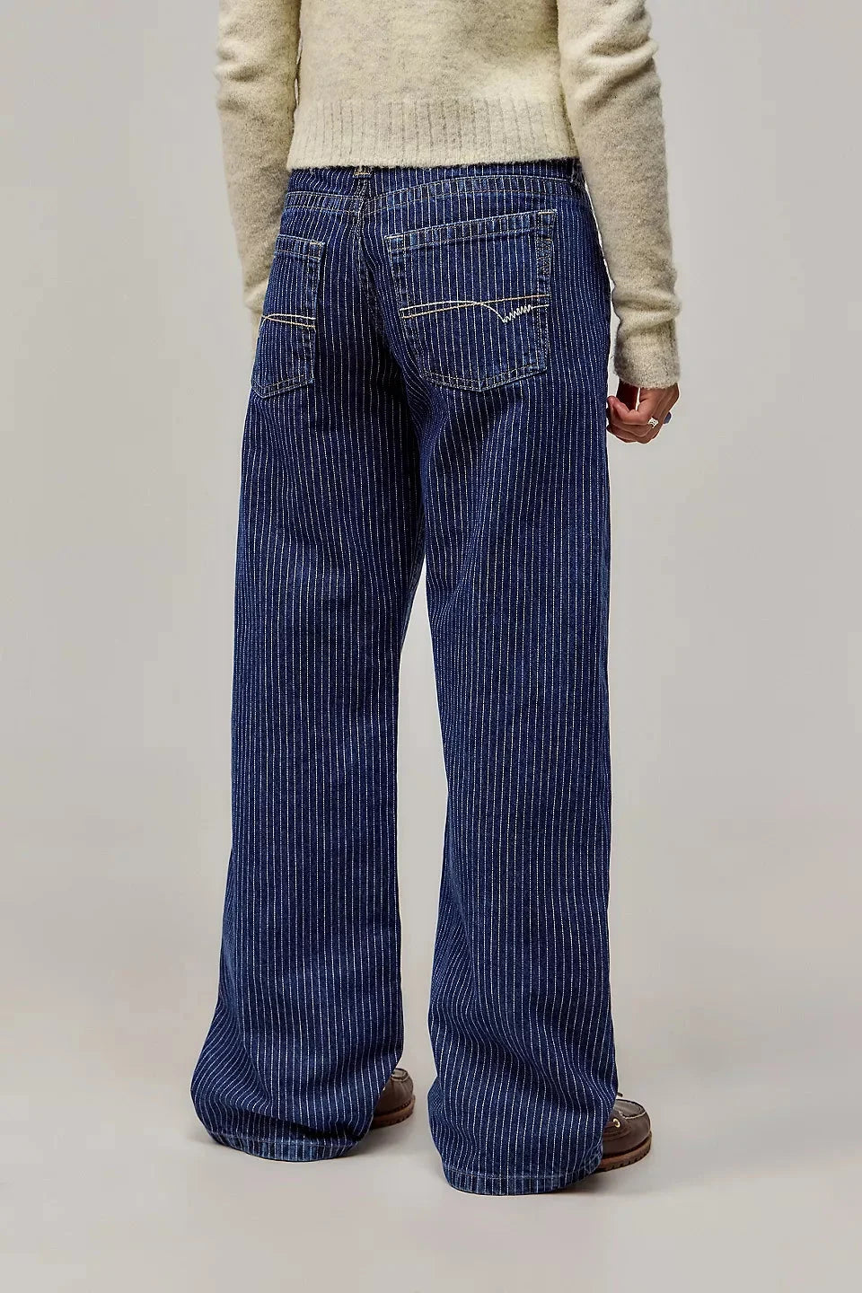 Model trägt elegante Damen Nadelstreifen Hose. Low-Waist Wide Leg Damenhose mit weitem Bein für stilvolle Auftritte.