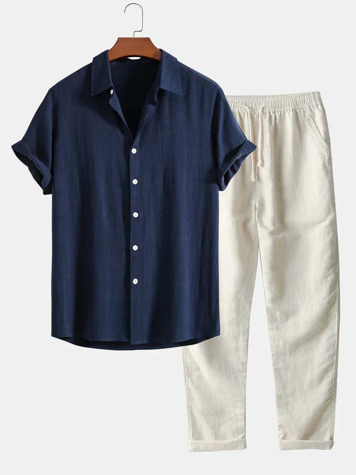Marineblaues Herren Kurzarmhemd und hellbeigefarbene Freizeithose, elegant auf einem Bügel hängend.