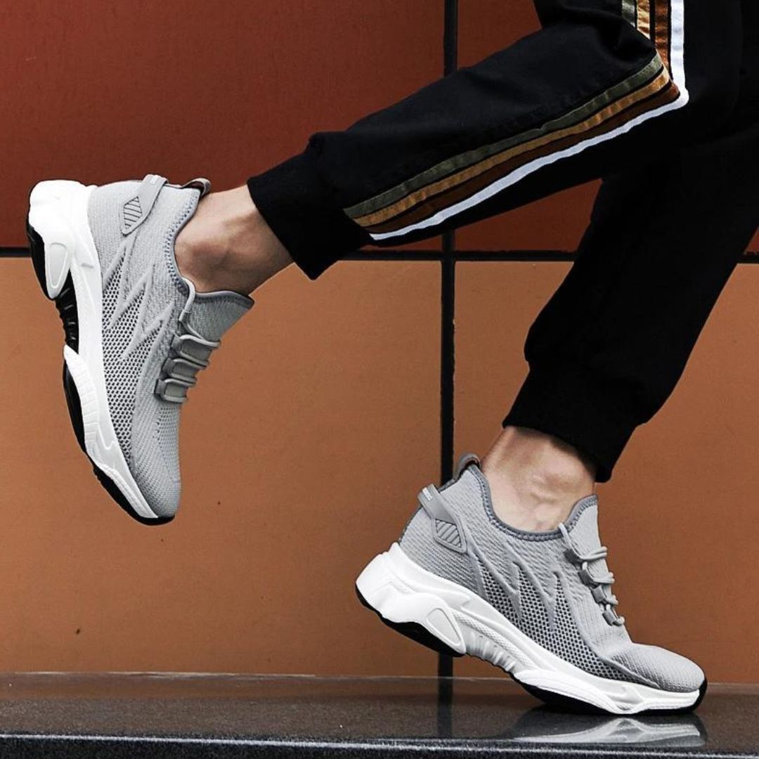 Ein Mann trägt die diskret erhöhenden Herren Sneaker; selbstbewusst & stilvoll im urbanen Umfeld.