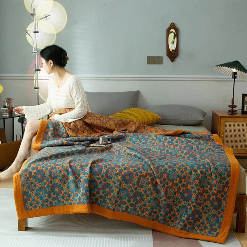 Baumwollbettdecke mit lebhaftem orange-blauem Muster, ideal als Tagesdecke für gemütliche Schlafzimmerdeko.