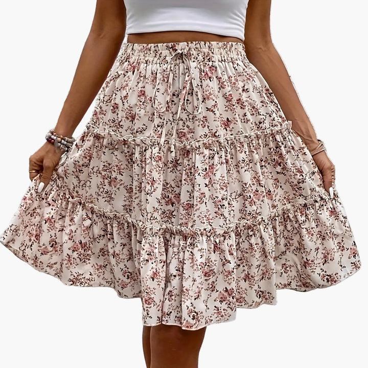 Rosafarbener Damen Boho Midirock mit fließendem Blumenmuster und Volant; eleganter Sommer- & Freizeitrock.