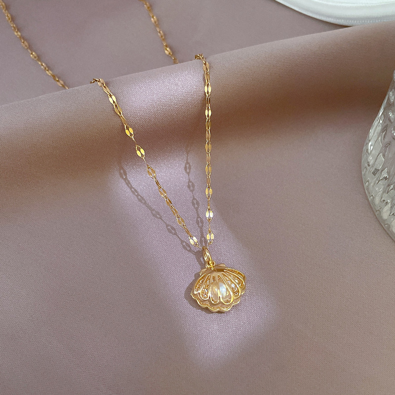 Zeitlose Damenhalskette: Perlenkette mit detailreichem Muschelanhänger, perfekt für den Meerjungfrauen-Stil.