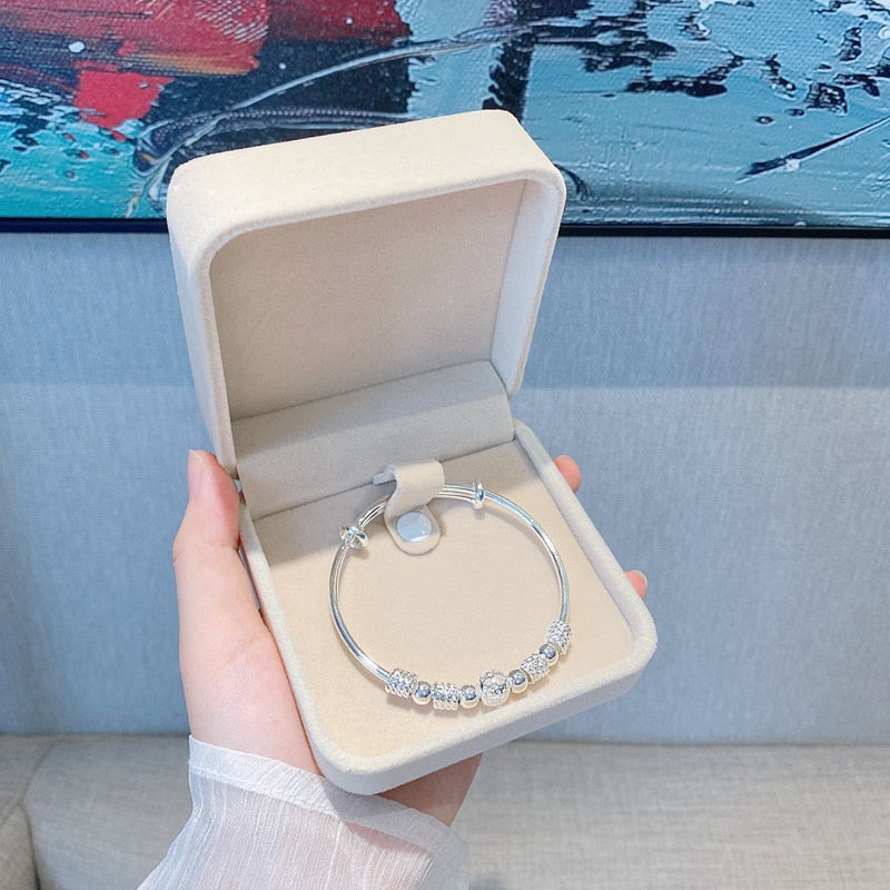 Damenarmband aus 925er Sterlingsilber mit Glücksperlen am Handgelenk. Eleganter und bequemer Alltagsschmuck.