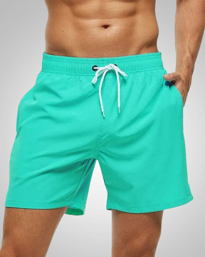 Moderner Mann trägt kurze, elastische Herren Badeshorts beim Schwimmen. Schnelltrocknend für Sport & Freizeit.