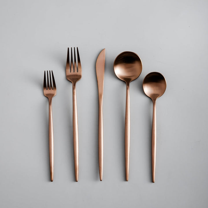 Schwarzbesteck im minimalistischen Design, detailreich fotografiert auf dunklem Hintergrund.