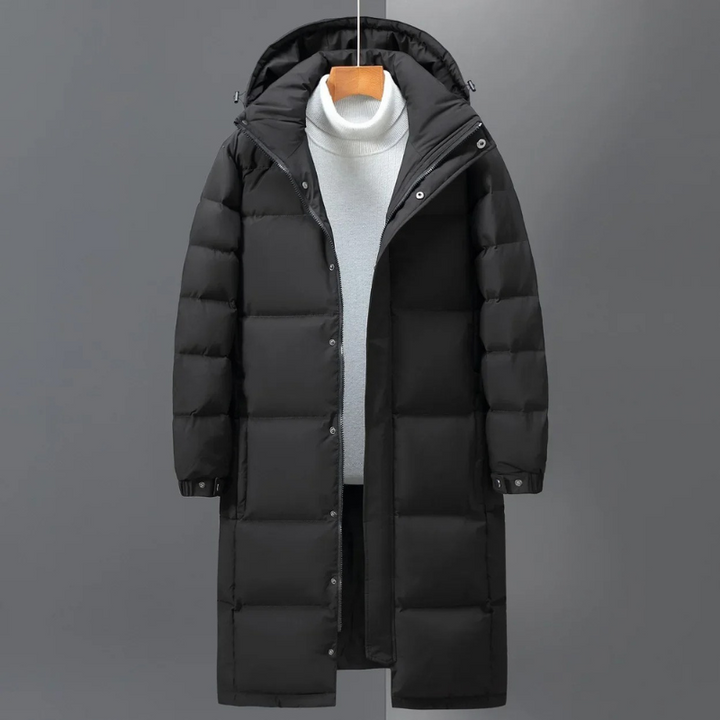 Grauer stilvoller Herren Steppmantel mit Kapuze. Warme, lange Winterjacke für Schutz und Komfort in der Herrenmode.