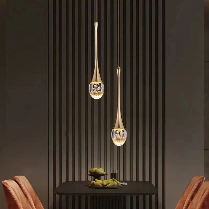 Moderne Glas Pendelleuchte mit goldener Fassung. Schafft warmes Licht im Wohnzimmer oder Essbereich.