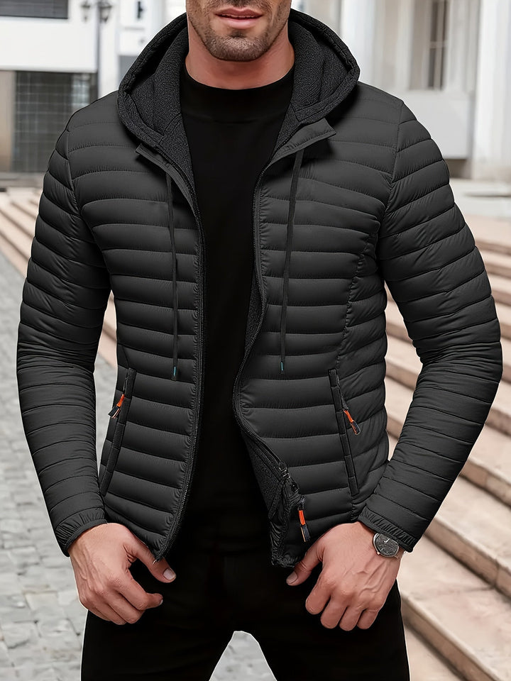 Gesteppte Herren Kapuzenjacke mit durchgehendem Reißverschluss. Modische Outdoorjacke für sportliche Herrenmode.
