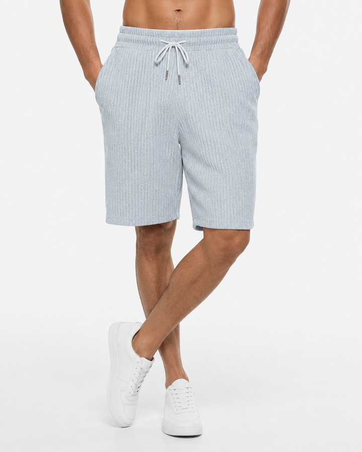 Mann trägt elegante Herren Strandshorts am Strand. Bequeme kurze Hose, ideal für Sommerurlaub & Freizeit.