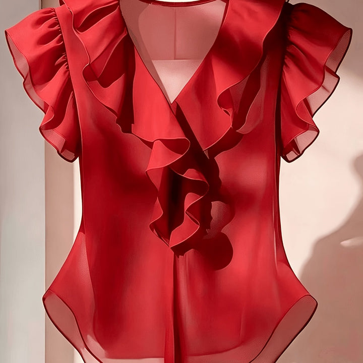 Detail des V-Ausschnitts einer eleganten Damenbluse mit Rüschen und Volantärmeln.