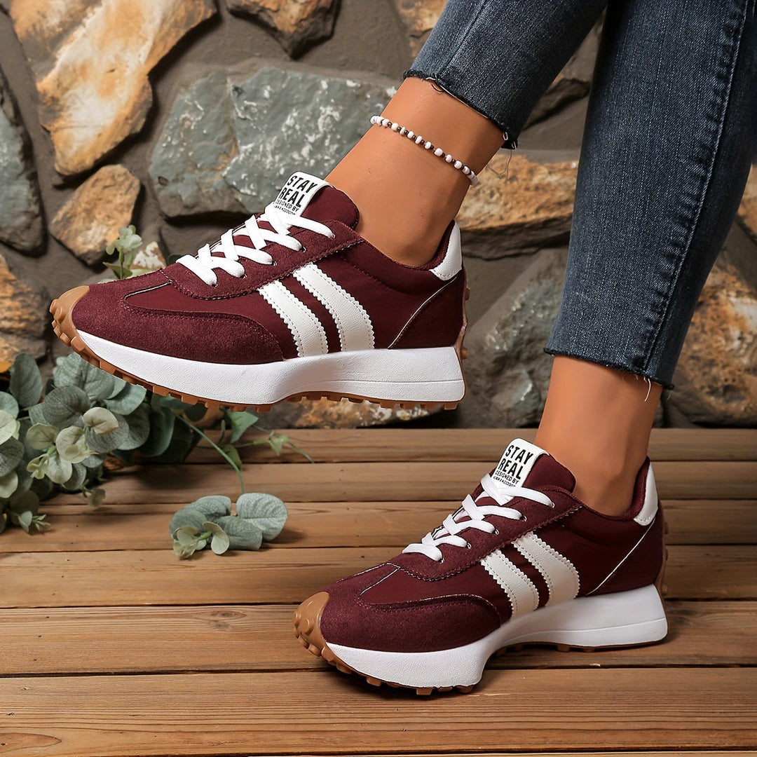 Damen Retro-Sneaker von der Seite, zeigen das dynamische Design und die bequeme Sohle.