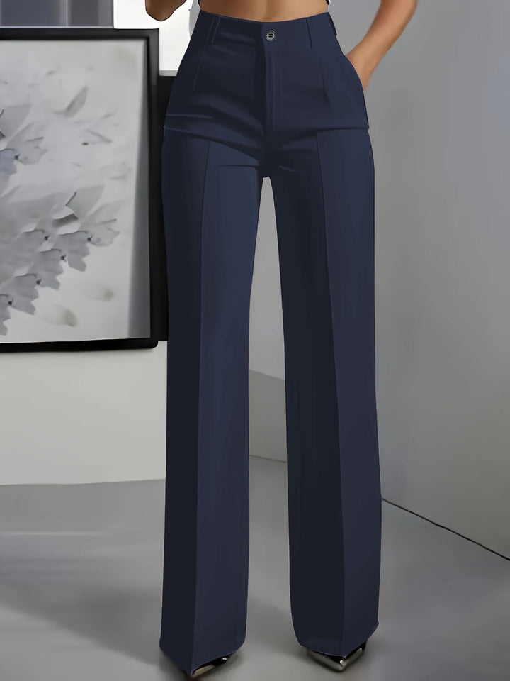 Model trägt hochtaillierte Anzughose für Damen mit geradem Schnitt, kombiniert mit eleganter Bluse.