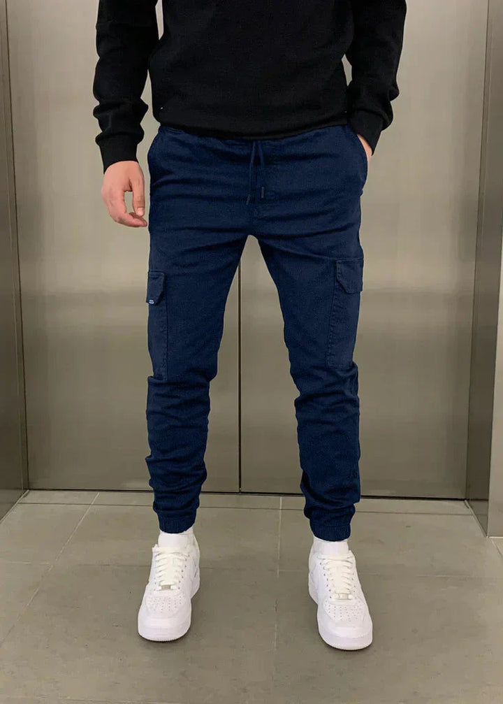 Model trägt Herren Cargo-Jogginghose: Entspannter Streetwear-Look mit Stil. Bequeme Hose für Freizeit & urbane Abenteuer.