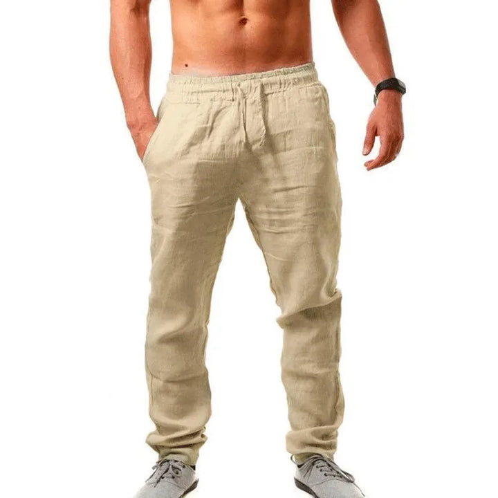 Mann spaziert in atmungsaktiver Herrenhose weites Bein mit Elastikbund. Komfortable Sommerhose für Freizeit & Reisen.