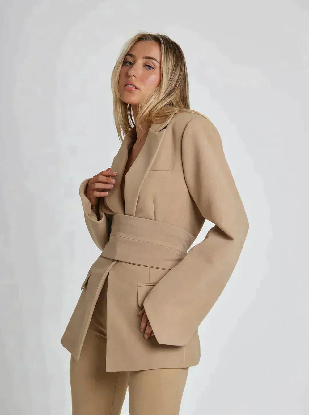 Beiger Damen Gürtel Blazer, tailliert und figurumspielend. Perfekt für elegante Freizeit-Outfits.