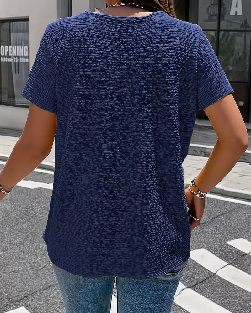 Feminin-elegante Kurzarm-Bluse für Damen, strukturiertes Design mit Kragen und Goldknöpfen. Vielseitiges Top.