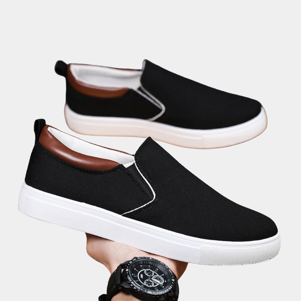 Mann trägt moderne schwarze Loafer Slipper, elegant kombiniert mit Anzughose. Bequemer Business Loafer.