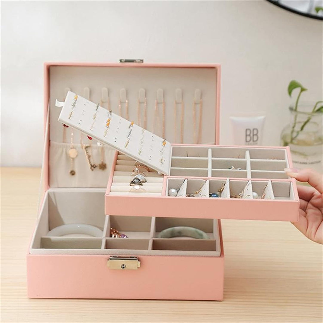Geöffnete doppellagige Schmuckbox aus PU-Leder für Damen mit Fächern für Ringe, Ohrringe und Halsketten.