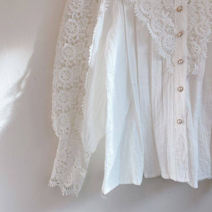 Modische Damenbluse Lucy in Bewegung, elegantes Spitzenoberteil mit Puffärmeln, fließend.