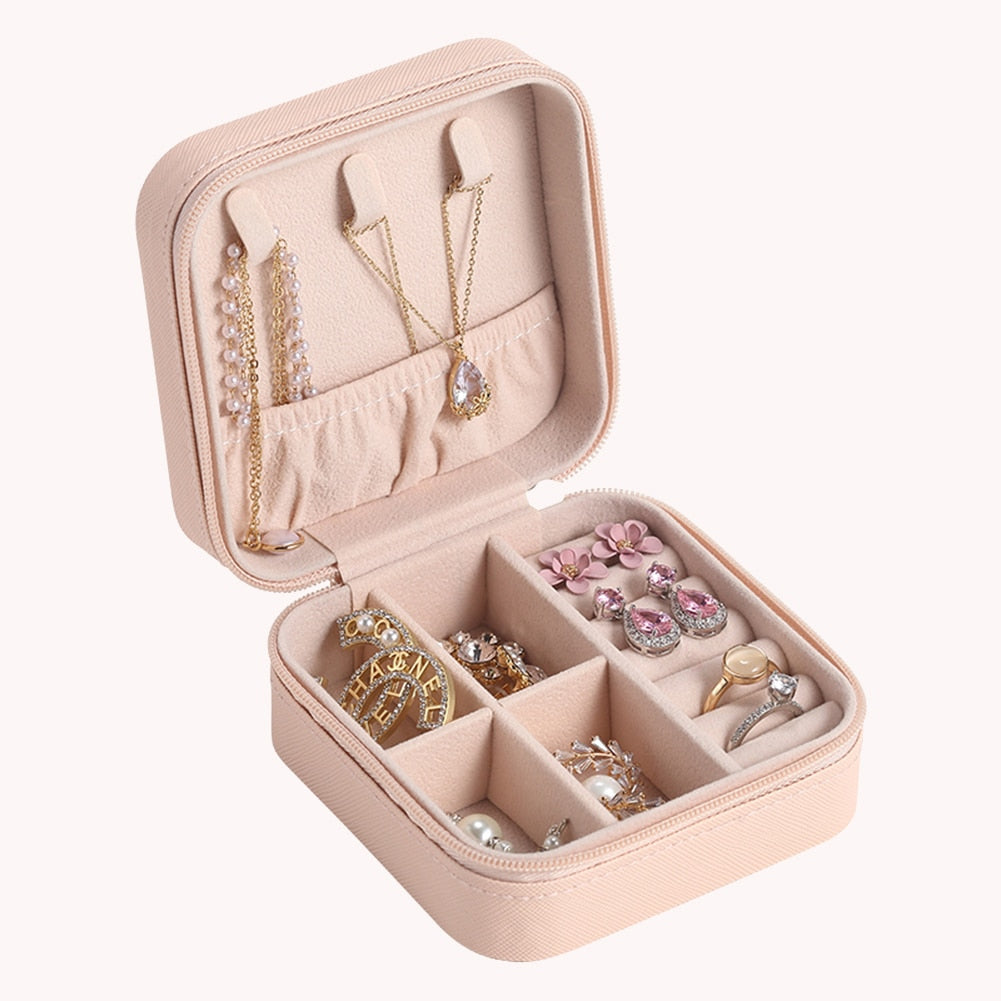 Portables rosa Schmuck-Etui aus Leder zur sicheren Aufbewahrung von Ringen, Ohrringen und Schmuckstücken auf Reisen.
