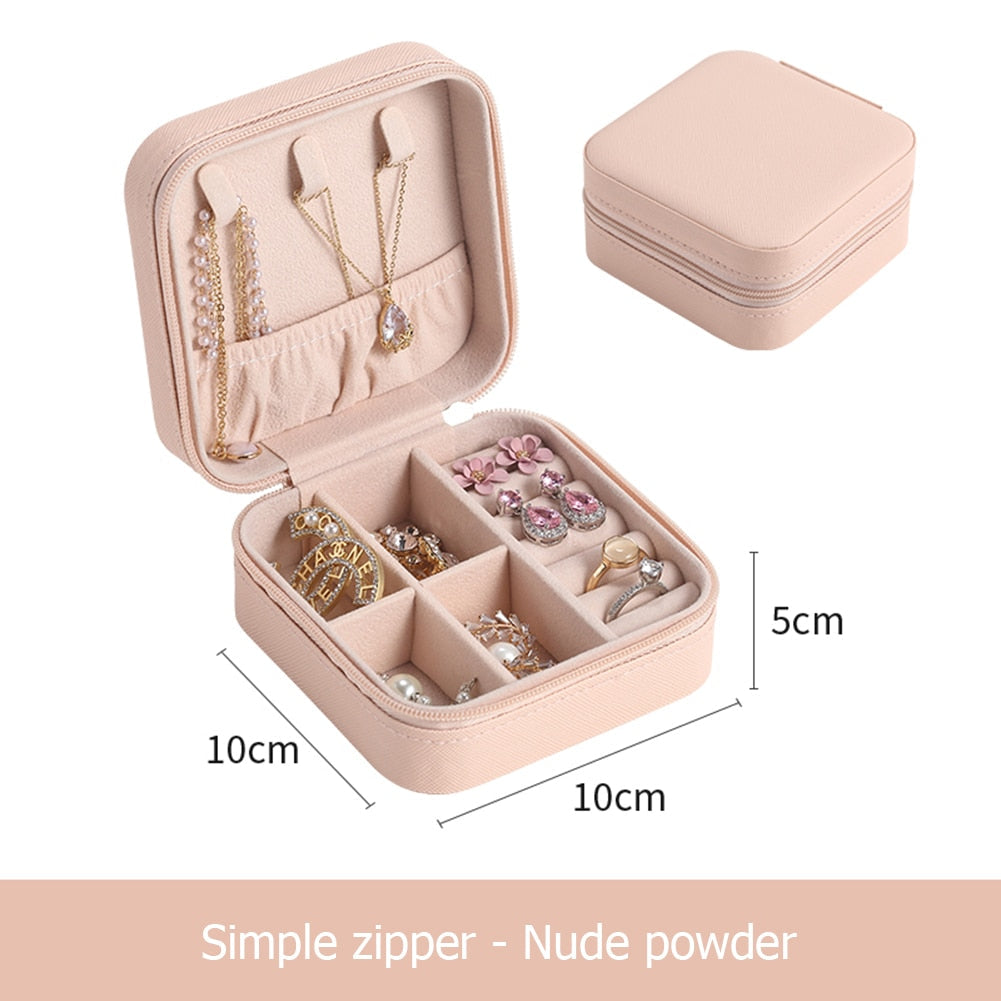 Mehrere Reiseschmuck-Organizer in Schwarz, Rosa, Blau und Grau, nebeneinander. Perfekt für Accessoires.