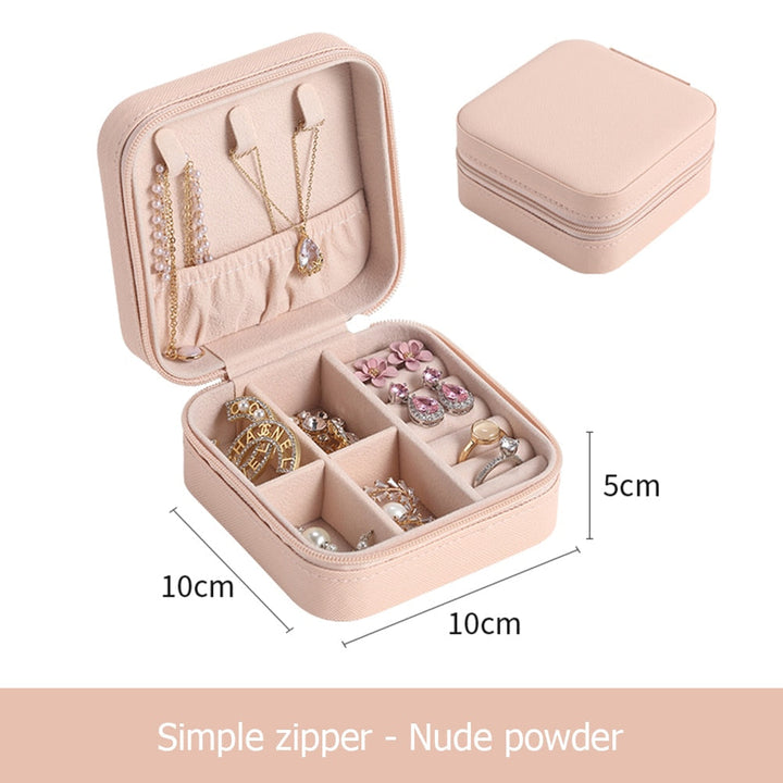 Mehrere Reiseschmuck-Organizer in Schwarz, Rosa, Blau und Grau, nebeneinander. Perfekt für Accessoires.