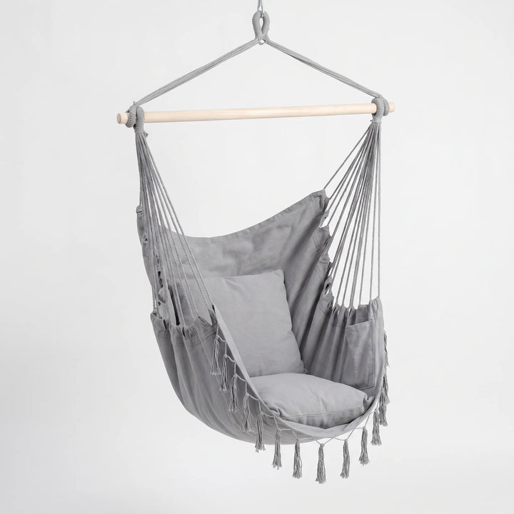 Boho-Hängesessel aus hellem Canvas-Stoff, schafft eine entspannte Atmosphäre.