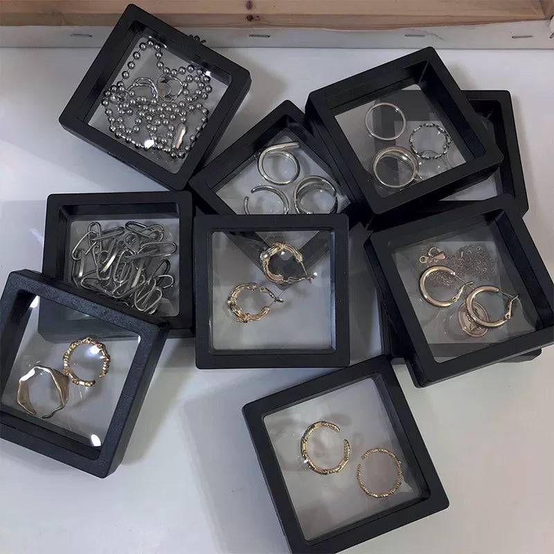 Mehrere schwebende Schmuckdisplays (10er Set), klare Sicht auf Ringe, Anhänger und Münzen.