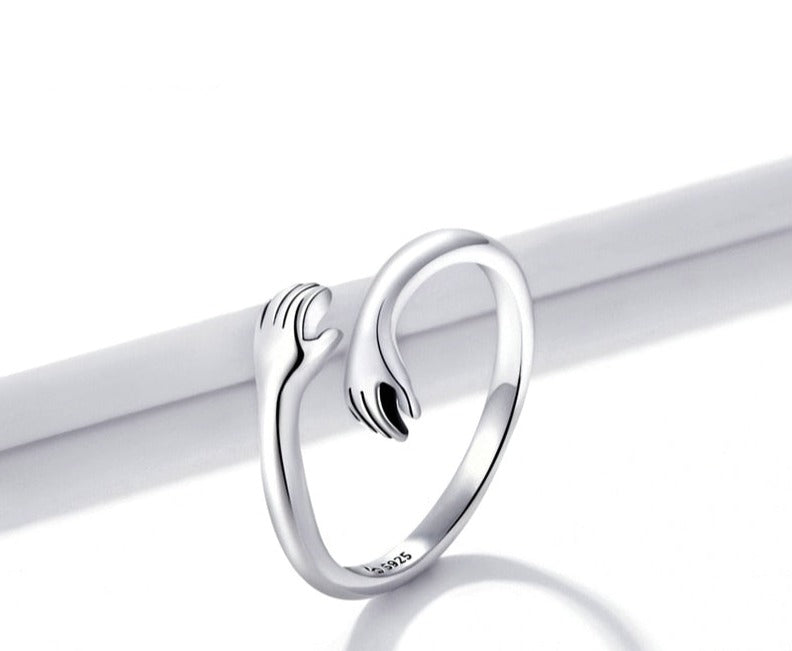 Nahaufnahme des filigranen Damen Umarmungsrings in Silber, symbolisiert eine liebevolle Umarmung.