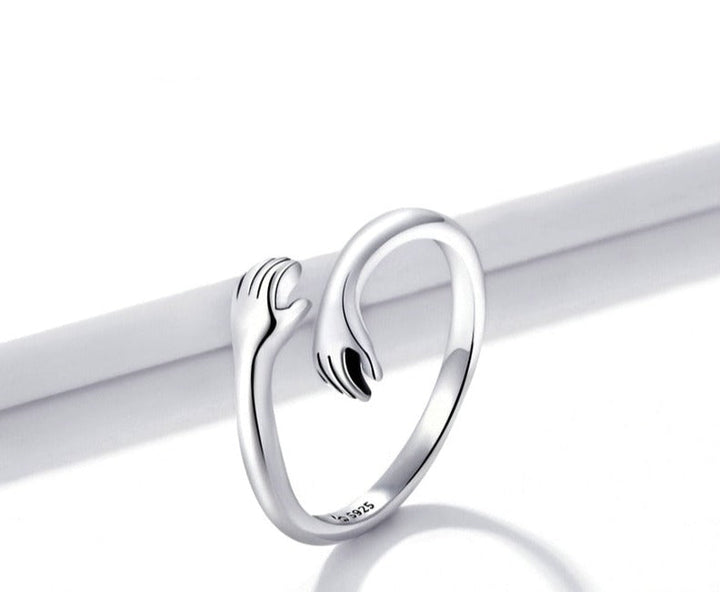 Nahaufnahme des filigranen Damen Umarmungsrings in Silber, symbolisiert eine liebevolle Umarmung.