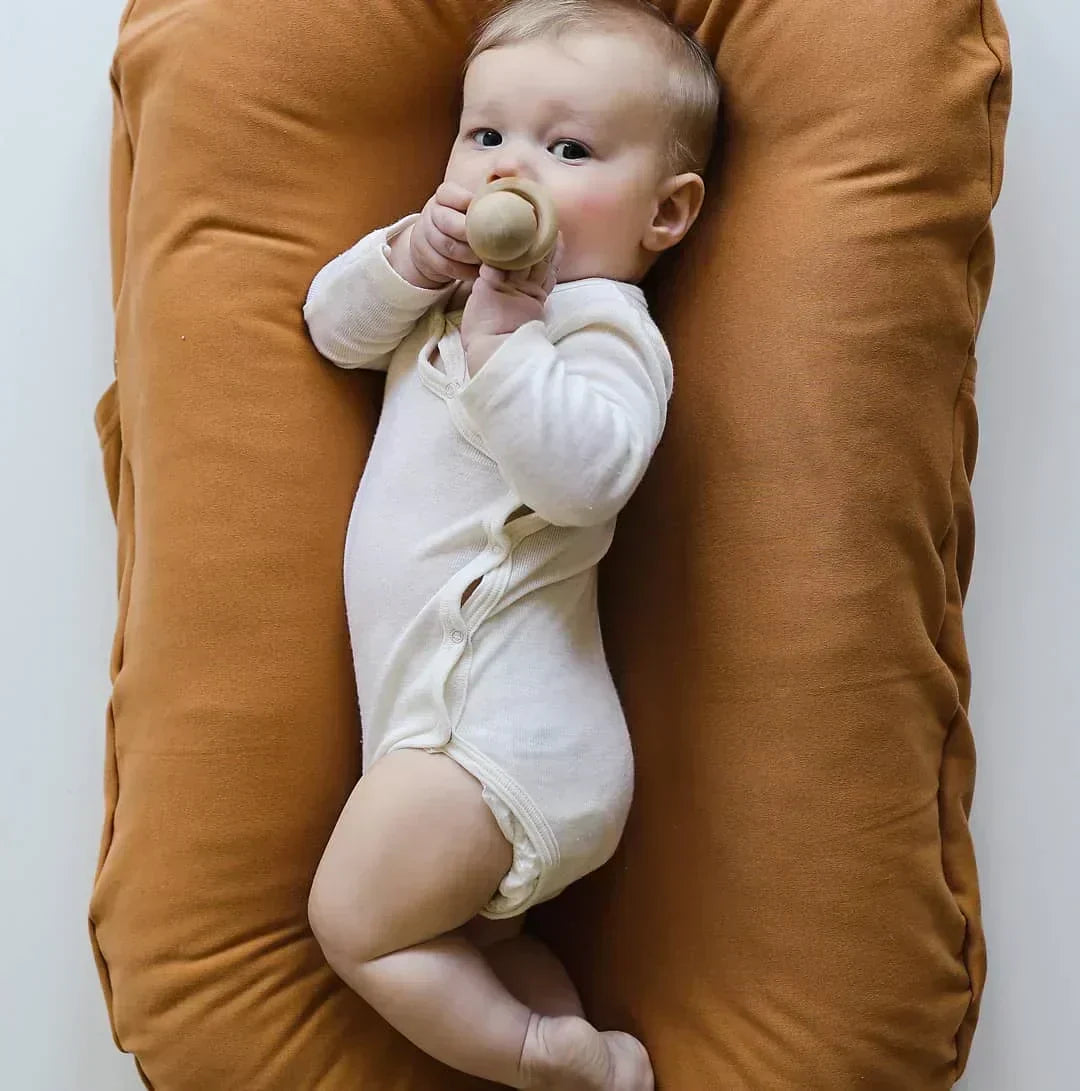 Tragbares CuddleNest Babynest aus Baumwolle, ideal als Reise-Schlafplatz für Neugeborene.