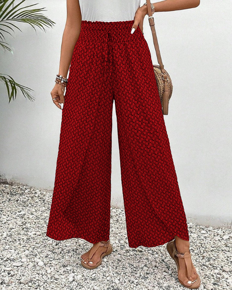 Lässige Damenhose mit weitem Bein und Muster. Geometrisches Design in Rot, Grün, Schwarz. Ideal für Frühling.