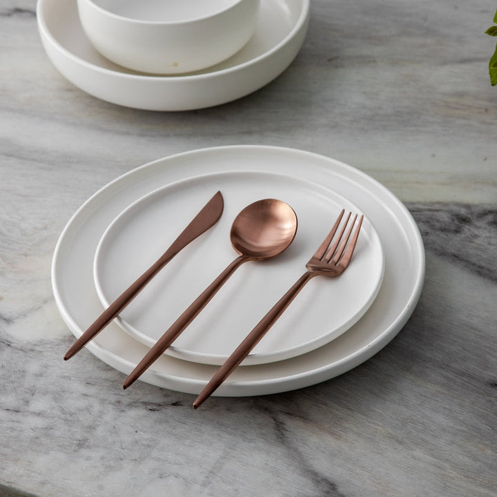 Roségoldenes Besteckset, bestehend aus Messer, Gabel, Löffel, für moderne Tischkultur.