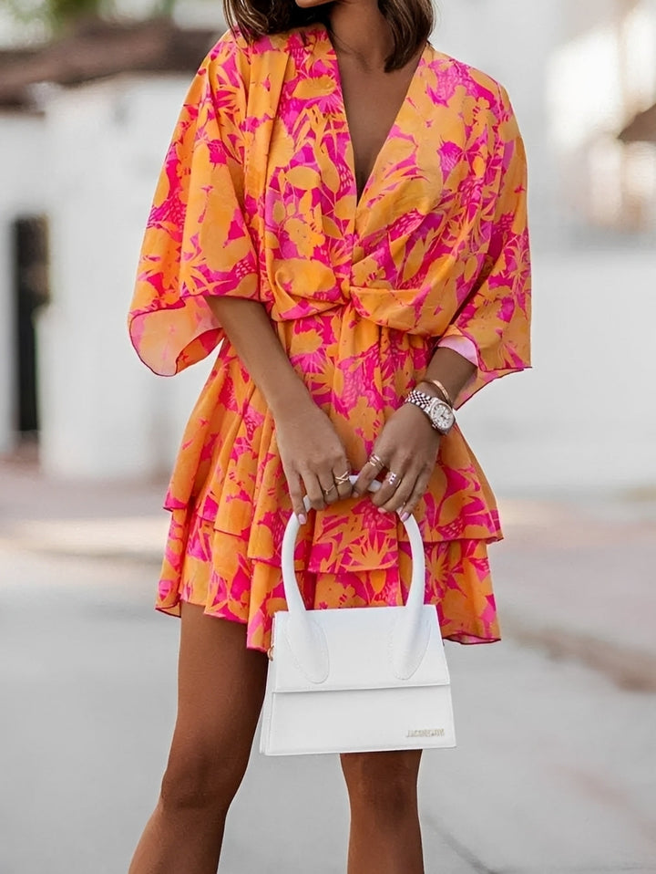 Damen Blumen Minikleid mit fließenden Kimonoärmeln und V-Ausschnitt. Stylisches Sommerkleid mit Rüschensaum.
