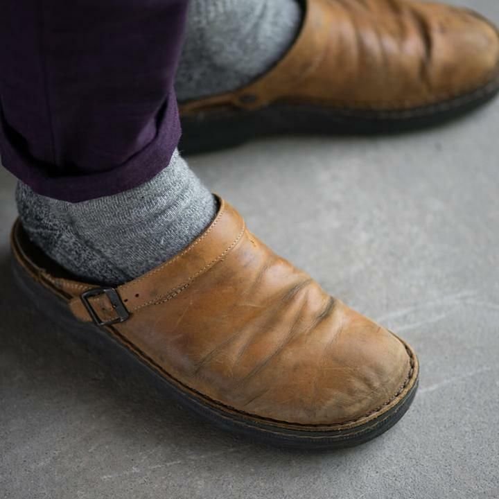 Mann trägt orthopädische Herren Pantoletten Mules. Bequeme Slip-on Schuhe für Alltagskomfort & Fussgesundheit.