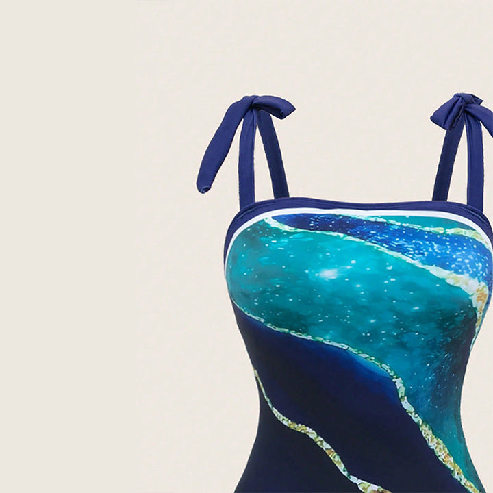 Blauer Damen Einteiler Badeanzug Set mit elegantem, transparentem Wickelrock. Perfekt für Urlaub & Pool.