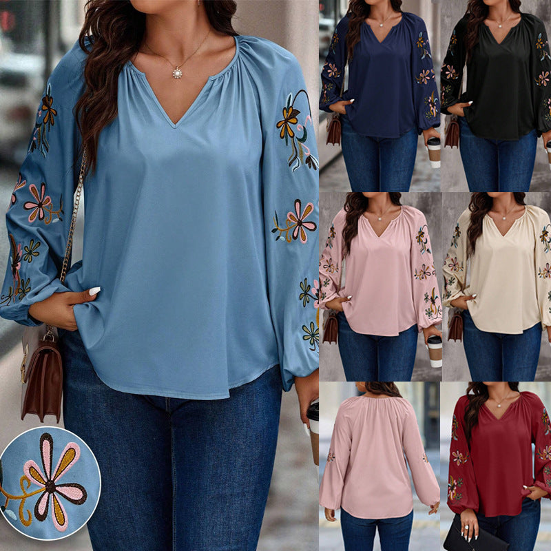 Elegante Damenbluse mit V-Ausschnitt & Blumen-Stickerei an lockeren Ballonärmeln. Perfekt für Sommer & Büro.