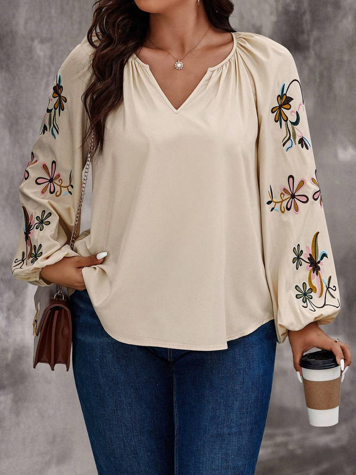 Casual-elegante Damenbluse mit V-Ausschnitt, floraler Stickerei an Ballonärmeln. Lockere Passform für Sommer Fashion.