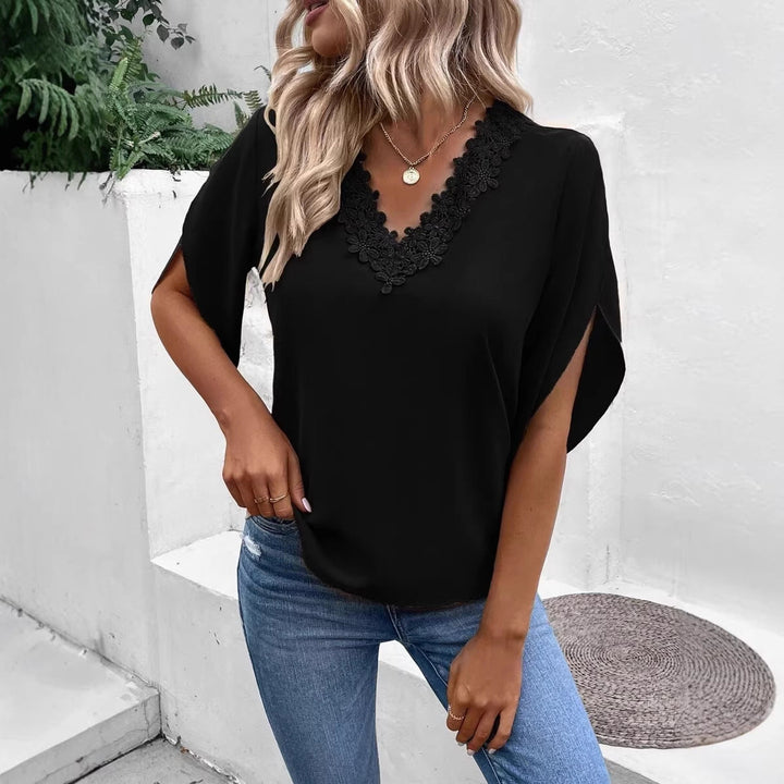 Detailaufnahme der Spitze einer eleganten Damenbluse mit V-Ausschnitt und weiten Fledermausärmeln.