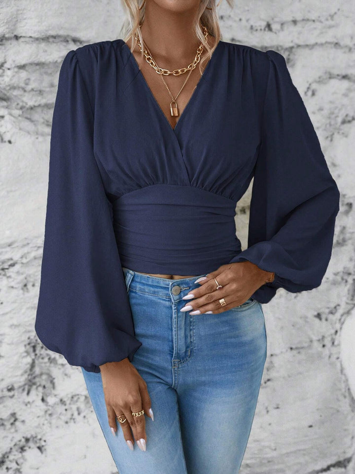 Nahaufnahme des Damen Wickel-Cropped-Tops, zeigt Ballonärmel, V-Ausschnitt und geraffte Taille Textur.