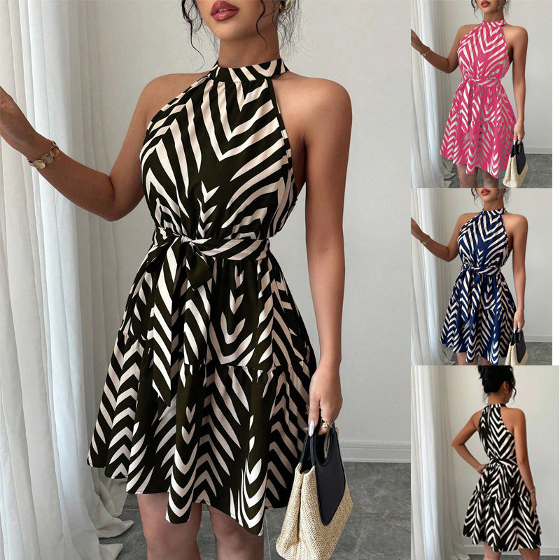 Elegantes Damen Neckholder-Sommerkleid mit Taillengürtel & gestuftem Rock. Ärmelloses Urlaubskleid mit Grafik-Print.