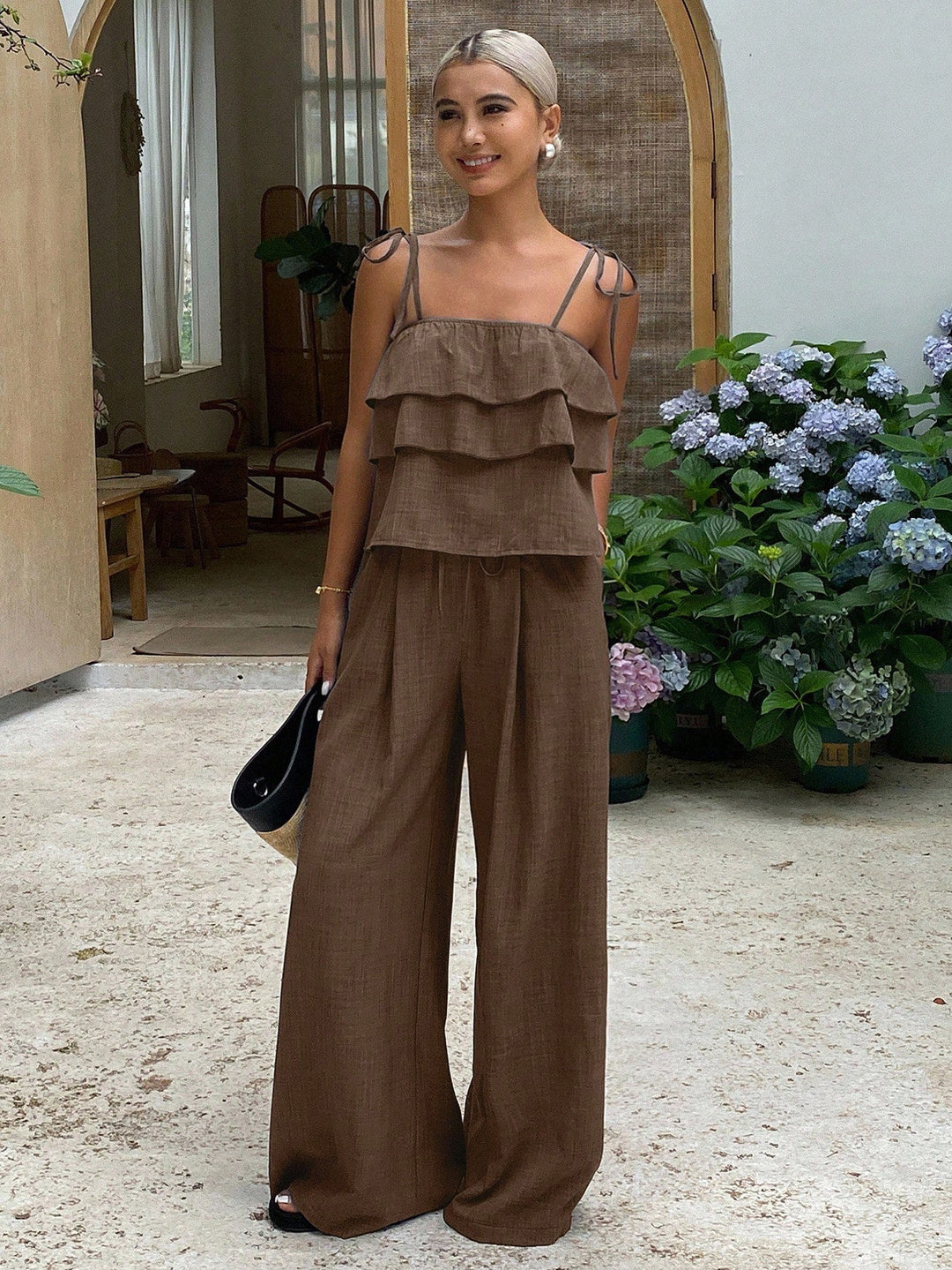 Model trägt einen lässig-eleganten Damen Zweiteiler mit Volant-Top und weiter Palazzo-Hose für den Sommer.