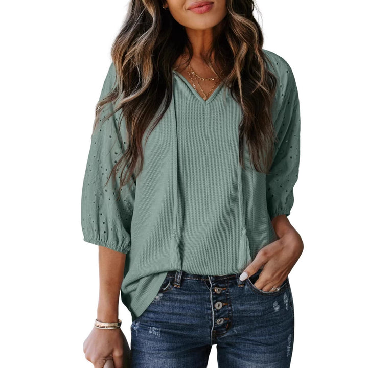 Feminin-elegantes Damen Waffelshirt mit V-Ausschnitt, bestickten Puffärmeln & dekorativen Quasten-Details.