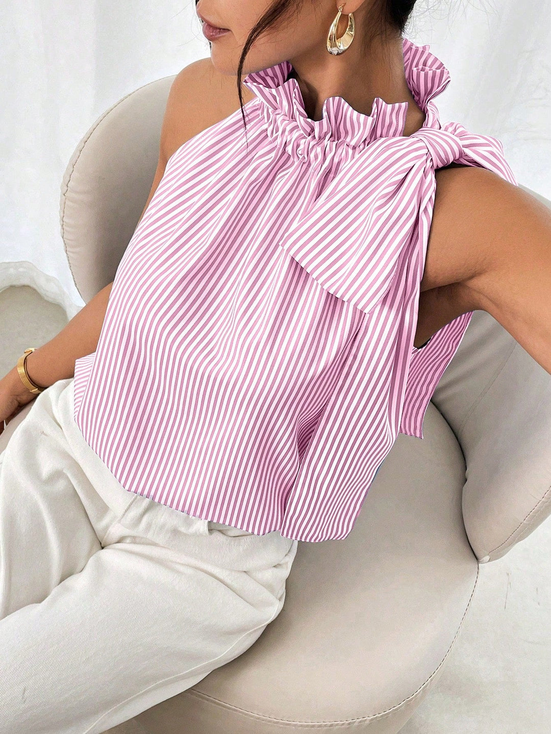 Stilvolle ärmellose Damenbluse mit elegantem Stehkragen und charmanter Schulterschleife. Feminine Mode.