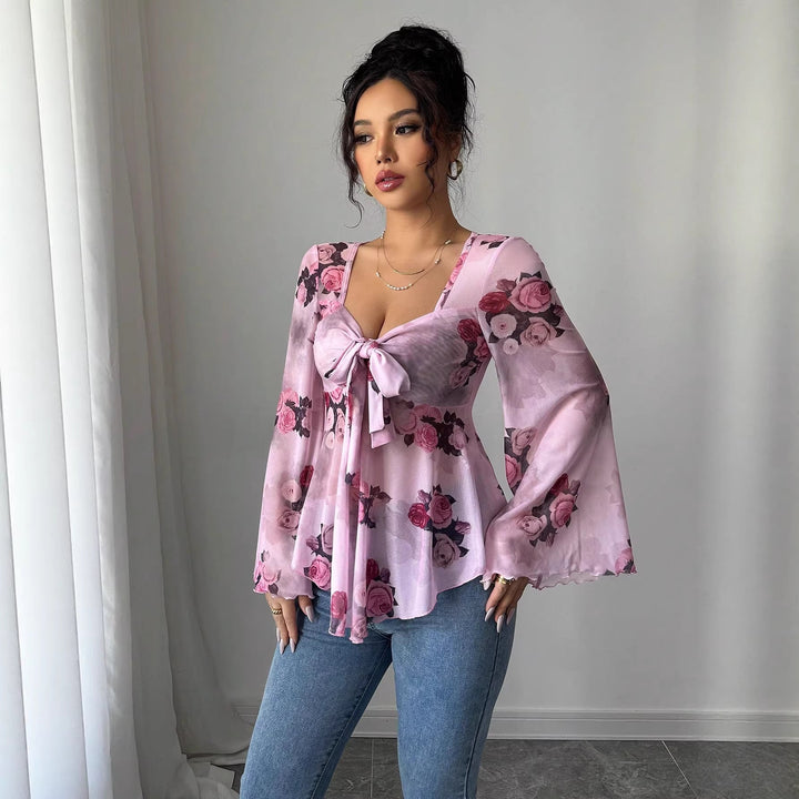 Detailansicht der Knotenfront einer transparenten Babydoll-Bluse mit floralem Muster.