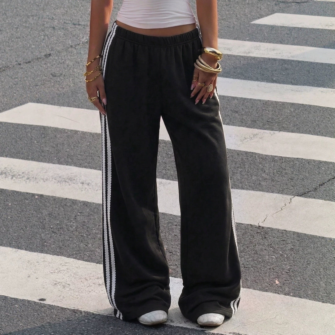 Sportliche Damen Freizeithose, weite Passform, Seitenstreifen für modernen Athleisure-Streetstyle.
