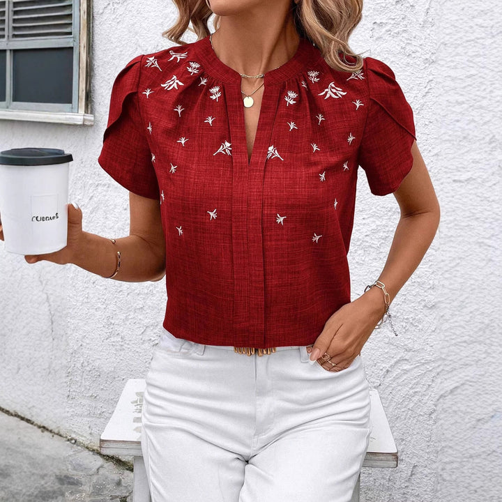 Schicke Kurzbluse für Damen mit elegantem Stehkragen und aufwendiger floraler Stickerei.