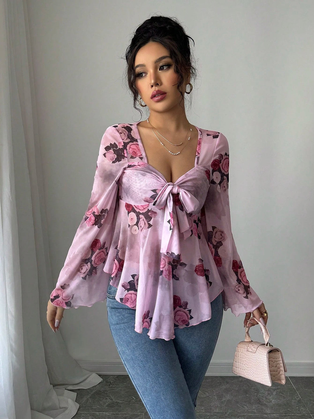Zarte, transparente Damenbluse mit floralem Print, Babydoll-Design und Knoten vorne.