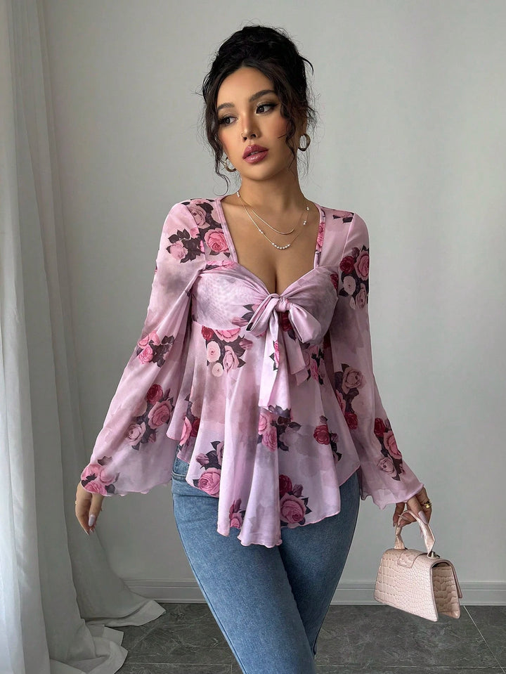 Zarte, transparente Damenbluse mit floralem Print, Babydoll-Design und Knoten vorne.