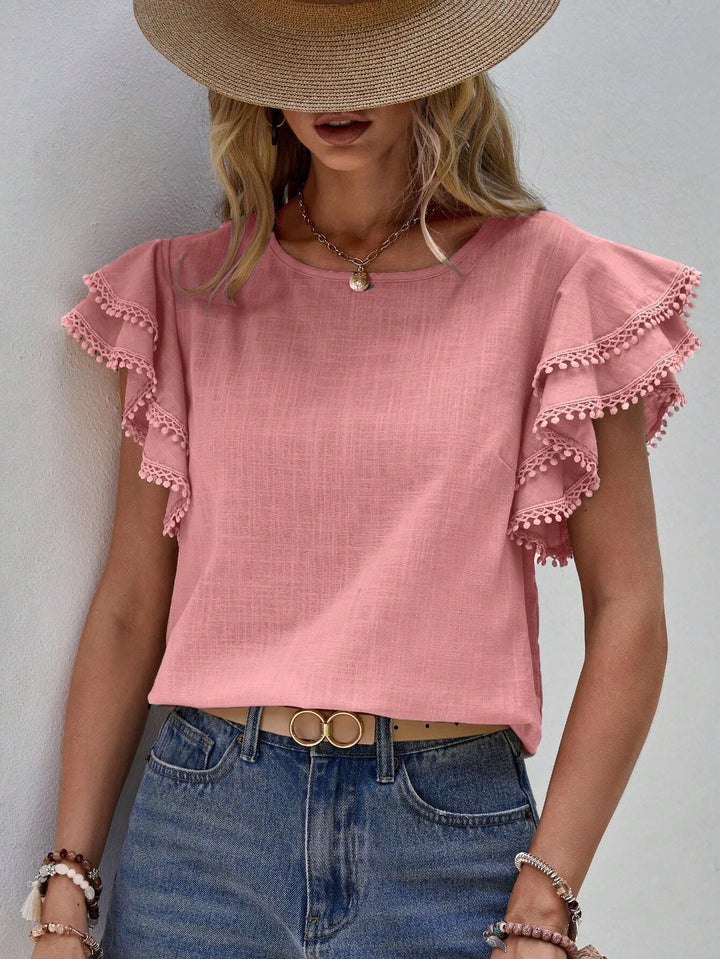 Detailreiche Damen Sommerbluse: elegante Volants, zarter Spitzenbesatz und verspielte Pompon-Akzente.